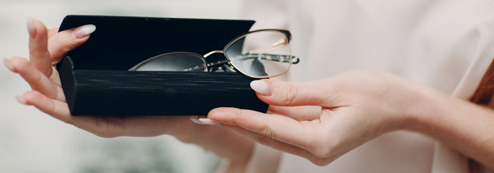 A person holding an eyeglasses case with a pair of glasses in it.